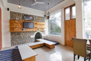 a living room with a stone wall with a fireplace at White Water Inn Mcleodganj in Dharamshala