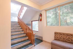 a staircase in a house with two windows at White Water Inn Mcleodganj in Dharamshala