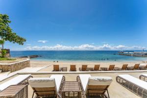 una playa con un montón de sillas y el océano en OMP 15C-T2, Seaview, Free Pool & Beach Access, Near Airport, FAST WI-FI, Netflix en Punta Engaño