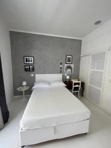 a bedroom with a large white bed and a desk at Rome, Beautiful Apartment in a Vintage Building in Lido di Ostia