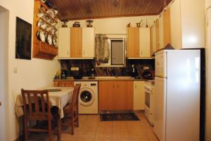 a kitchen with a table and a white refrigerator at Nadia's House 1 in Afantou
