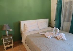 two swans sitting on a bed in a bedroom at Nadia's House 1 in Afantou