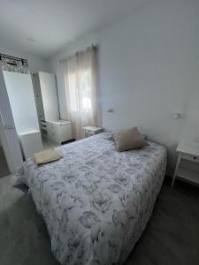 um quarto com uma cama com um edredão branco em Casa Las Tías Tazacorte em Tazacorte
