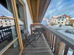 einen Balkon mit 2 Stühlen und Schnee in der Unterkunft Liebling's Platzl in Eberfing