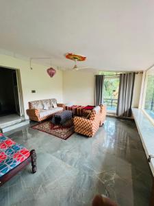a living room with two couches and a flat screen tv at Cloud 9 Homestay in Attigundi