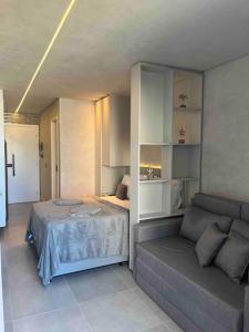 a bedroom with a bed and a couch at Flat 207 Villa del Porto in Porto De Galinhas
