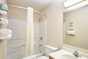 une salle de bain avec des toilettes blanches et un lavabo dans l'établissement Super 8 by Wyndham Greenville, à Greenville 11 autres photos