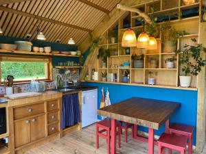 a kitchen with a wooden table and a blue wall at Green Valley Cabin in Dorchester