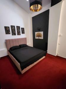 - une chambre avec un lit et un tapis rouge dans l'établissement Karma caffe&rooms, à Bucarest