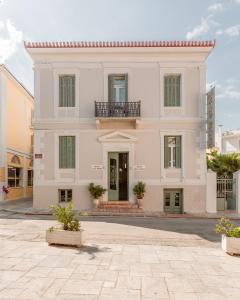a large white building with a balcony on a street at King Othon Boutique Hotel in Nafplio
