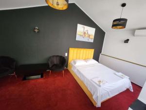 a room with a bed and a chair in it at Karma caffe&rooms in Bucharest