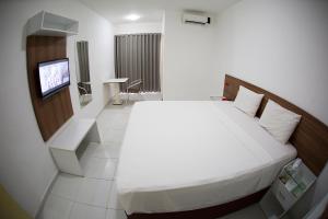 pokój hotelowy z łóżkiem i telewizorem w obiekcie Rede Andrade Araras w mieście Aracaju