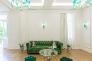a living room with a green couch and a table at King Othon Boutique Hotel in Nafplio