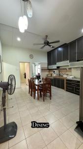 a kitchen with a table and chairs and a fan at Eehome in Ipoh