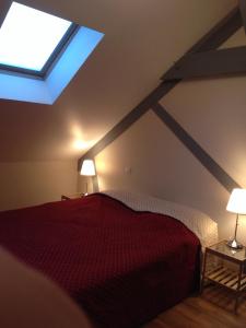 a bedroom with a red bed and a window at Villa Varco in Auxonne