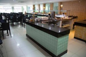 a restaurant with a bar and tables and chairs at Araras Praia Hotel in Aracaju