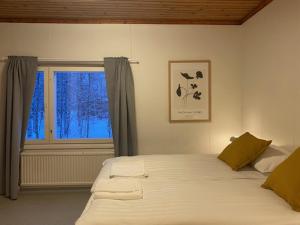 a bedroom with a large bed with a window at Apartment MUMMOLA in Rovaniemi