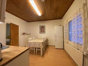 uma cozinha com uma mesa e um frigorífico branco em Apartment MUMMOLA em Rovaniemi