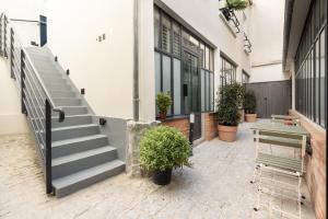 a building with stairs and potted plants on the sidewalk at District Nation in Paris