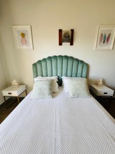 um quarto com uma cama grande e uma cabeceira azul em Sunset Lover Aparthotel Guadiana em Monte Gordo