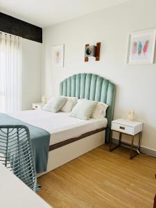 a bedroom with a bed with a blue headboard at Sunset Lover Aparthotel Guadiana in Monte Gordo