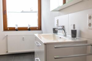 a bathroom with a sink and a window at Haus Martina in Poppenhausen