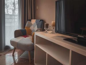 sala de estar con escritorio, TV y silla en Apartment Podgorica Center, en Podgorica