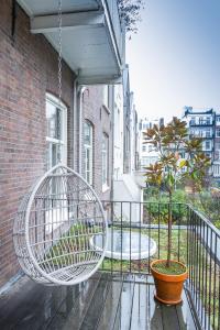 un fauteuil roulant sur une terrasse couverte avec un pot dans l'établissement Vondel 99, à Amsterdam