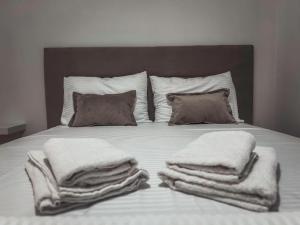 Una cama con mantas blancas y almohadas. en Apartment Podgorica Center, en Podgorica
