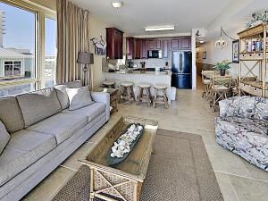 Una sala de estar con un sofá y una cocina. en Beach Club #206A, en Pensacola Beach