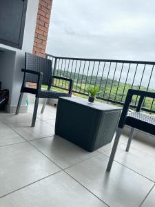 uma varanda com duas cadeiras e uma mesa com uma planta em Coastal Retreats em Ballito