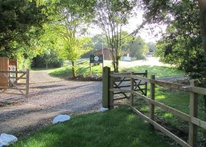 a wooden fence next to a road with a sign at Spindlewood Lodges in North Wootton