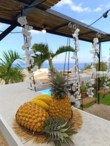 un ananas et des bananes sur une plaque sur une table dans l'établissement Lilie location sud, à Petite Île