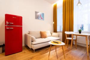 a living room with a white couch and a red refrigerator at Cosy Apartment Koliste 25 in Brno