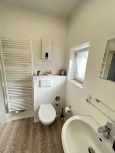 a white bathroom with a toilet and a sink at Moderne Wohlfühl-Wohnung in Troisdorf Altenrath in Troisdorf