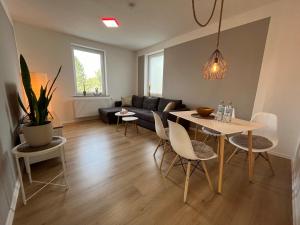 uma sala de estar com uma mesa e cadeiras e um sofá em Moderne Wohlfühl-Wohnung in Troisdorf Altenrath em Troisdorf