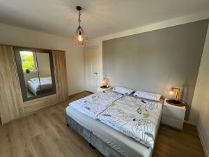 um quarto com uma cama, 2 candeeiros e um espelho em Moderne Wohlfühl-Wohnung in Troisdorf Altenrath em Troisdorf