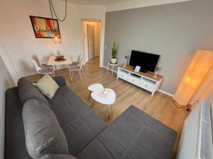 uma sala de estar com um sofá cinzento e uma mesa em Moderne Wohlfühl-Wohnung in Troisdorf Altenrath em Troisdorf