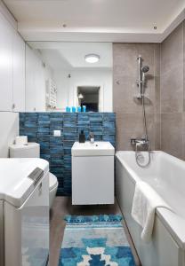 łazienka z wanną, toaletą i umywalką w obiekcie Winogrady Loft Apartment w Poznaniu