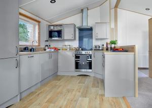 a kitchen with white appliances and wooden floors at Crealy Theme Park And Resort in Clyst Saint Mary