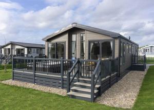 a small house with a porch and a fence at Crealy Theme Park And Resort in Clyst Saint Mary