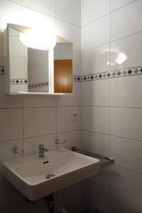 een witte badkamer met een wastafel en een spiegel bij Bellevue L 031 - PLEASANT apartment 6 pers in Veysonnaz