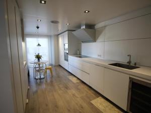 uma cozinha com armários brancos e uma mesa com uma cadeira em Apartamento Llançà, 3 dormitorios, 6 personas - ES-228-76 em Llançà