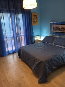 1 dormitorio con 1 cama grande y cortinas azules en By the sea, en Passoscuro