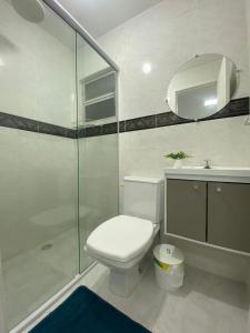une salle de bain blanche avec toilettes et douche dans l'établissement Apartamento 1 quadra do mar em Ipanema - PR, à Pontal do Paraná 14 autres photos