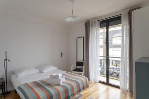 - une chambre blanche avec un lit et des serviettes dans l'établissement La Cocotte - Maison pour 6 quartier Sainte-Thérèse, à Rennes