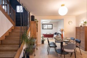 - un salon avec une table et des chaises ainsi qu'un escalier dans l'établissement La Cocotte - Maison pour 6 quartier Sainte-Thérèse, à Rennes