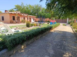 einen Hof mit weißen Stühlen und ein Haus in der Unterkunft Holiday Home Merie with pool in Benkovac