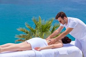 un hombre recibiendo un masaje de una mujer en una playa en Pietra e Mare - Mykonos Moments en Kalo Livadi