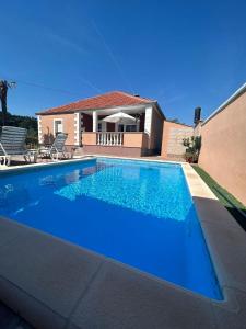 une grande piscine bleue en face d'une maison dans l'établissement Holiday Home Merie with pool, à Benkovac